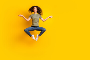 Full size photo of peaceful girl dressed striped t-shirt levitating in meditation pose isolated on vibrant yellow color background