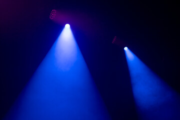 An empty stage, lit by spotlights and smoke before the performance