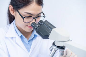 A female scientist is working with a microscope
