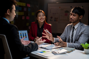 Three people are sitting at a table, talking and smiling