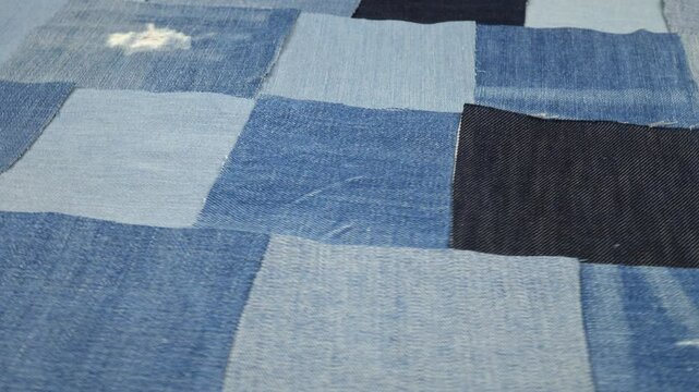 Pieces of the old jeans fabric, blue background. Recycling old jeans, sustainable zero waste lifestyle.