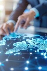 A global map of the world is spread out on an office table, with business people in suits pointing at different areas and discussing