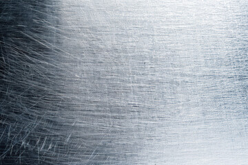 Fototapeta premium Close-up of a brushed stainless steel texture, showcasing fine, linear scratches and a metallic sheen. Ideal for backgrounds, industrial themes, and design elements.