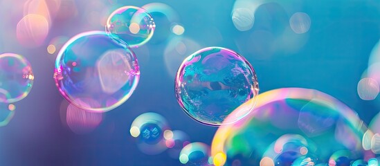 Naklejka premium Colorful soap bubbles floating against a vibrant blue backdrop ideal for showcasing with copy space image