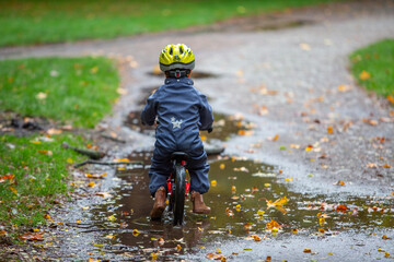 Kleinkind auf dem Laufrad im Herbst