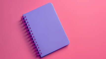 Purple notebook with spiral spring on magenta background viewed from above