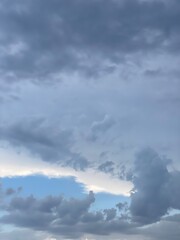 Obraz premium Blue, cloudy, moody sky. The sun is breaking through the cloud