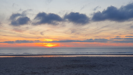 Ship on the sea. Beach at sunrise witn sand and water.