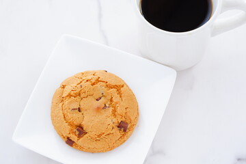 チョコレートがたっぷり入ったチョコチップクッキーとコーヒーでおやつの時間
