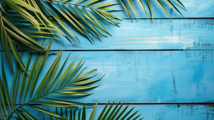 Palm leaf composition on blue wooden background Summer theme with space for text
