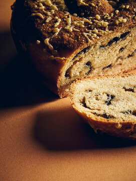 close up of a bread with a slice of it in front on an orange background