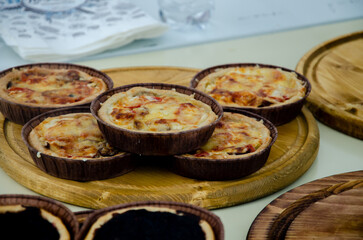 Delicious and fresh desserts in the form of tartlets on display behind glass