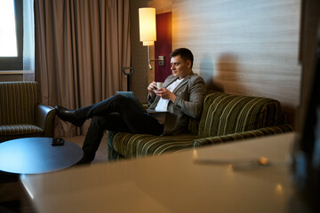 Entrepreneur using his portable computer over coffee in hotel room