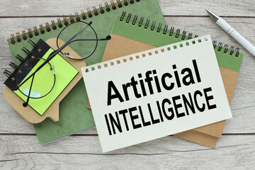 two notepads and glasses on the work table. text Artificial Intelligence