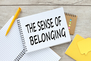 the Sense of belonging light background text on an open notepad near a yellow pen