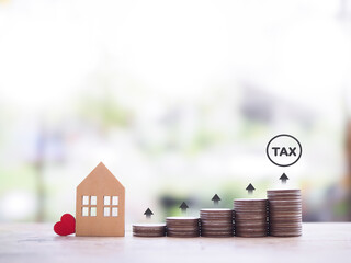 Miniature house and stack of coins with arrow rising. The concept of payment tax for house, Property investment, House mortgage, Real estate