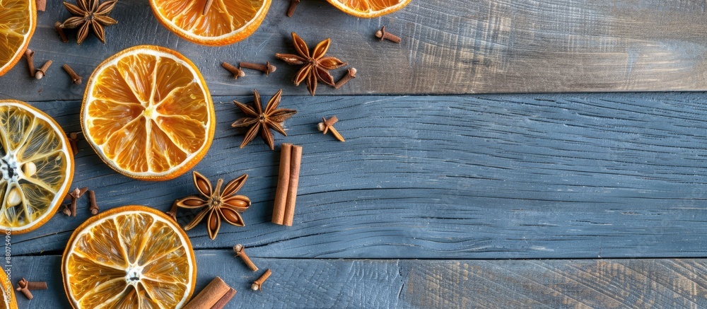 Poster flat lay composition on a grey wooden table featuring dry orange slices anise stars and cinnamon sti