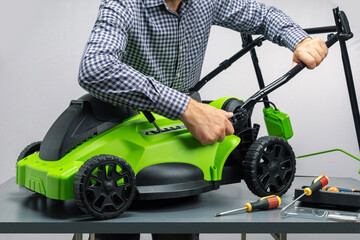 Professional repairman is repairing a lawnmower.