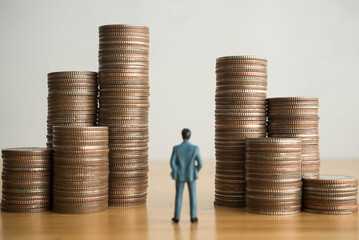 Businessman looking at heap coins with white wall background. Business, finance and economy...