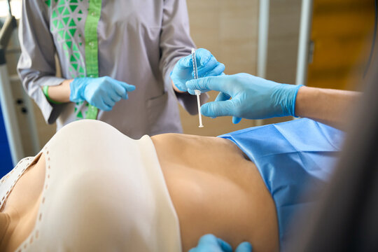 Nurse assisting dermatologic surgeon during local anesthetic injection