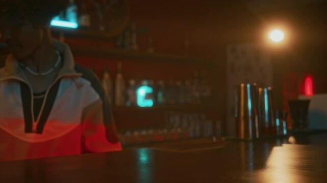 Cropped shot of young bartender putting two bottles of beer on counter for unrecognizable guest who returning empty bottle and taking two more at bar