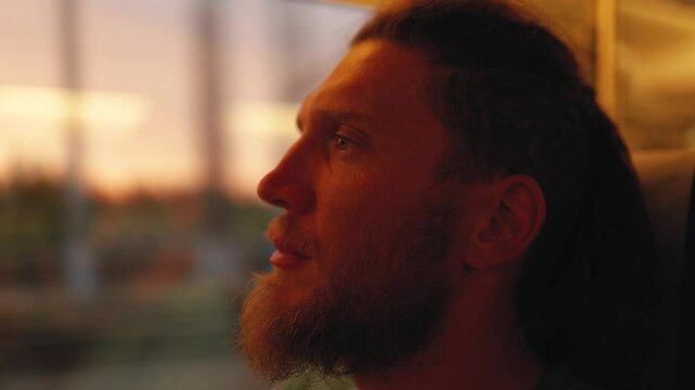 Man travelling by train looks out of window