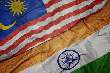 waving colorful flag of india and national flag of malaysia on the dollar money background. finance concept.