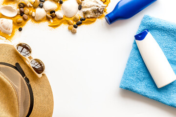 Summer beach background with shells and sea sand with sunbathe accessories, top view