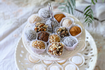 Variety of delicious gourmet brigadeiros being displayed on white cake stand