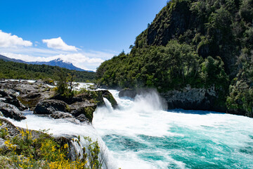 Vivid image showcasing a powerful waterfall amidst vibrant greenery under a clear blue sky