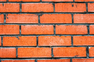 Obraz premium Close up of a brick wall with a unique pattern of orange and brown bricks, texture, background.