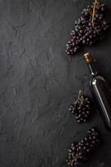 Red wine in the bottle with bunch of grapes, top view