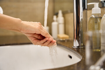 Close-up view woman washing her hands under running water