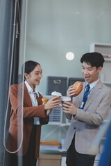 Successful young business people talking, working together in front of modern business building