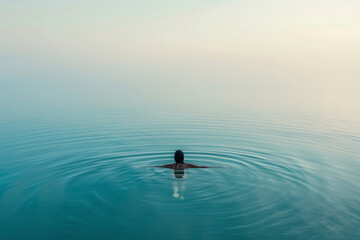Fototapeta premium woman swimming and floating in lake water, practicing meditation and breathing exercise, integration of mind and body at sunset in beautiful natural scenery