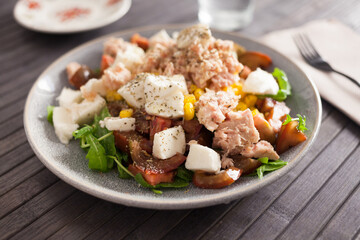 Plate of salad with tuna, corn, tomatoes and arugula