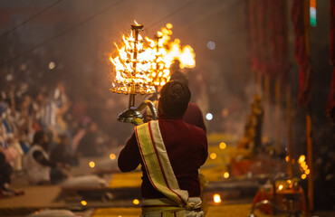 Ganga aarti, Portrait of young priest performing holy river ganges evening aarti at assi ghat in traditional dress with hindu rituals