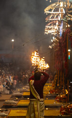 Ganga aarti, Portrait of young priest performing holy river ganges evening aarti at assi ghat in traditional dress with hindu rituals at dashashwamedh ghat.