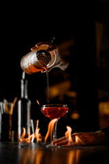 professional hands of cocktail maker making a chic alcohol cocktail with cognac in glass