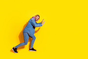 Naklejka premium Full size profile photo of nice young man push empty space wear denim jacket isolated on yellow color background