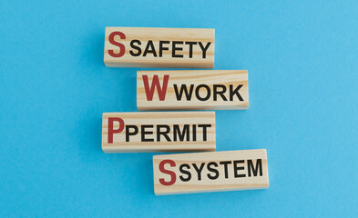 Safety Work Permit System text on Wooden Block on Blue Background