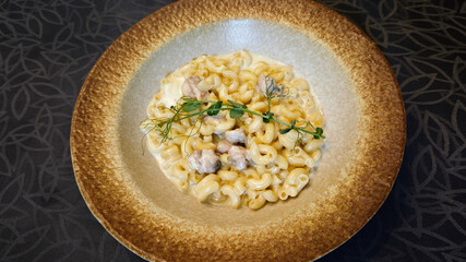 Elegant Truffle Mac and Cheese in Rustic Brown Plate with Black Patterned Background