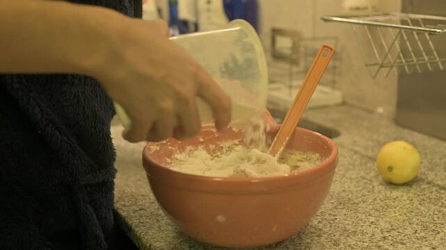 Agregando harina a la preparaci&oacute;n de la masa
