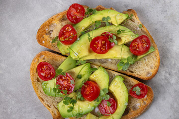 A slice of toasted sour dough bread with avocado and tomato on top