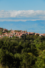 Signahi Signagi city town in Georgia. Sunny weather with clouds and mountains on a background. Roofs and houses on big hill. Travel in Sakartvelo, Georgia. 