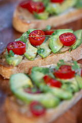 A slice of toasted sour dough bread with avocado and tomato on top