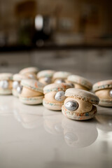 Composition with a soft macarons with silver dekor on a white marble table