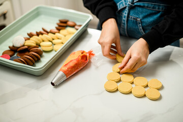 Multi-colored macaron preparations in a big plastic bowl on a white marble table