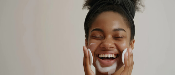 A smiling woman with a fresh, clean face, applying skincare products, exuding joy and confidence in her beauty routine.