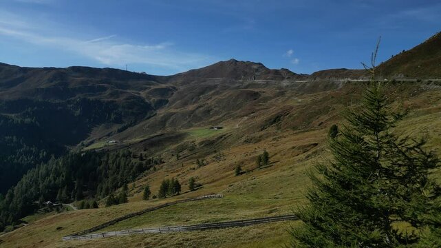 Luftaufnahme des Penser Jochs im Herbst bei Sonnenschein mit ein paar Wolken